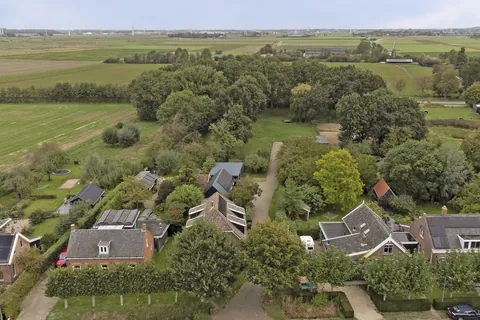Luchtfoto van het erf in Nisse met de open polder daarachter