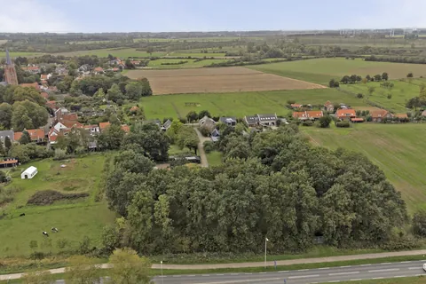 Luchtfoto van het perceel met het dorp Nisse, de kerktoren en de Zeeuwse polder