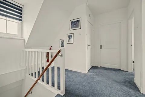 Overloop met trap en deuren naar de slaapkamers en badkamer