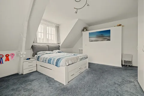 Slaapkamer 1 met dakkapel en raam op de tuin