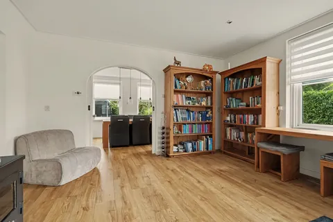 Ronde boogdoorgang van de woonkamer naar de eetkamer met de eettafel op de achtergrond